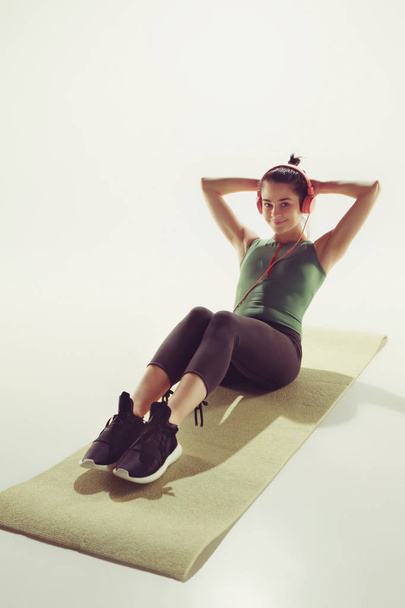 Vista frontal de una joven mujer estirando el cuerpo en clase de gimnasia
. - Foto, imagen