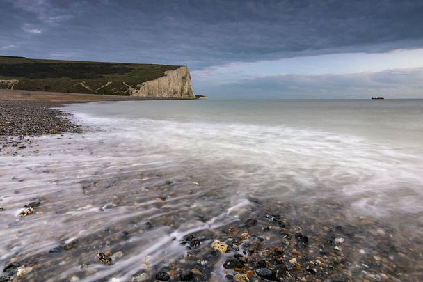 Sea and pebbles in Cuckmere Haven with the Seven Sisters cliffs - Photo, image