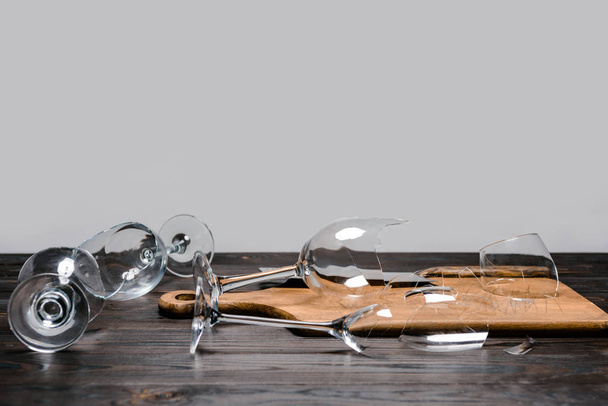 broken wineglasses and axe with wooden board on table - Photo, image