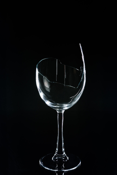 broken wineglass on black reflecting table  - Fotó, kép
