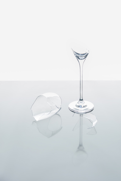broken wineglass on white reflecting table - Фото, изображение