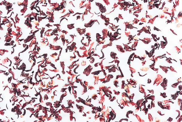 bovenaanzicht van verspreide gedroogde hibiscus thee geïsoleerd op wit - Foto, afbeelding