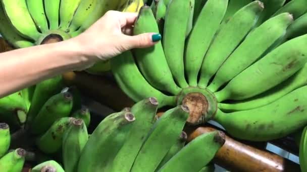 Femme sélectionnant frsh banane verte biologique dans le supermarché en Asie
. - Séquence, vidéo