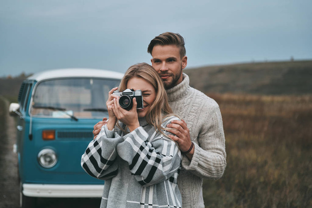 woman photographer with camera, man embracing his girlfriend - Photo, Image