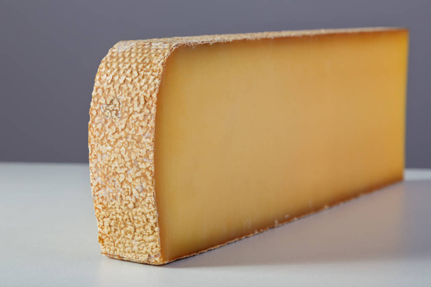 a large piece of milk cheese on a gray background - Photo, Image