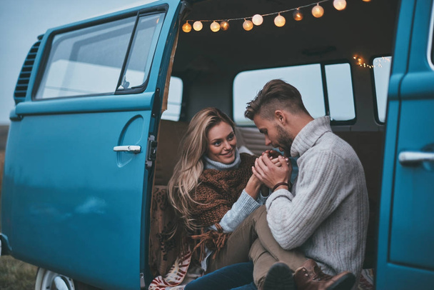 Handsome young man warming up his girlfriend hands while enjoying their road travel - Photo, Image