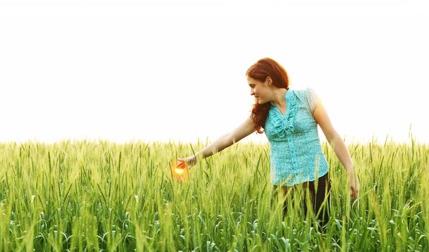 rude kaukaski kobieta spaceru w dziedzinie młoda pszenica zielony.  - Zdjęcie, obraz