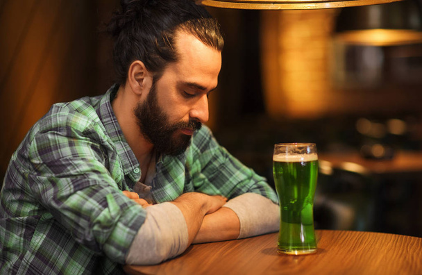 lonely man drinking green beer at bar or pub - Фото, зображення