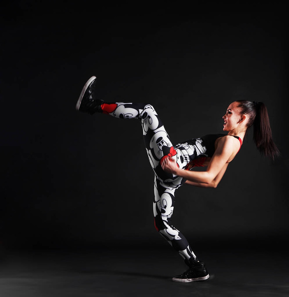 Portrait of young woman practicing  martial arts - high kick  - 写真・画像