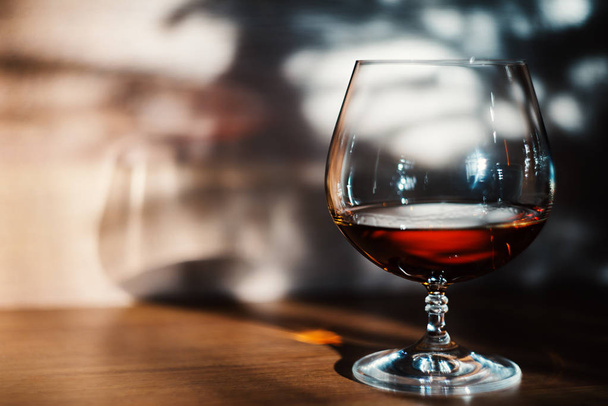 Vaso de coñac sobre la mesa concepto de alcohol
 - Foto, Imagen