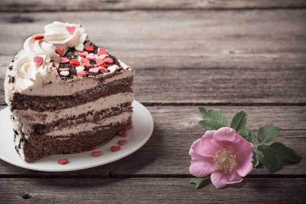 chocolate cake with rose on old wooden background - Photo, image