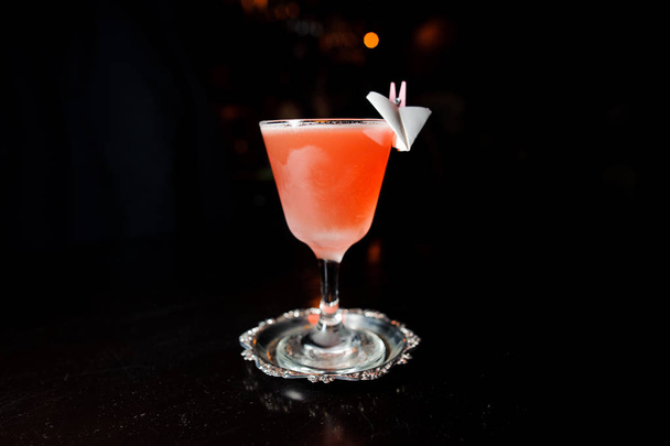 alcoholic cocktail of pink color stands on a special plate on a black background - Foto, Imagen