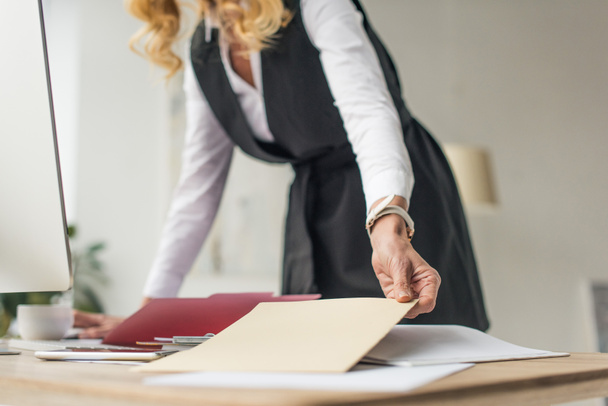 selective focus of businesswoman holding envelope at workplace - Foto, Bild
