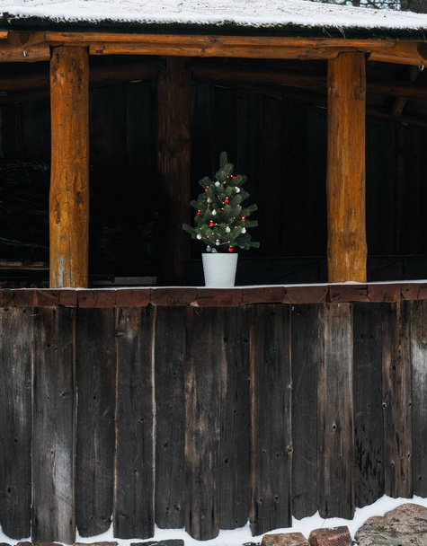 Árbol de Navidad en el edificio de madera
 - Foto, Imagen