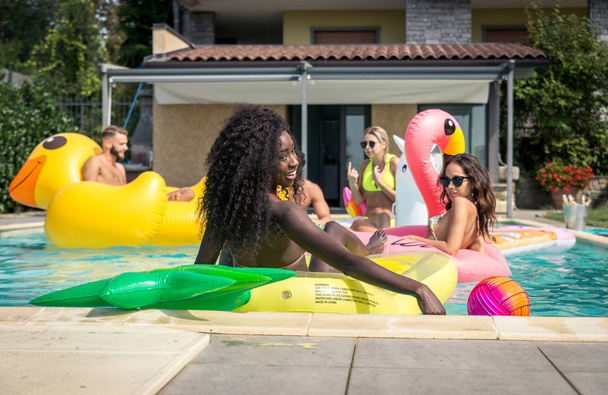Friends having fun in a swimming pool - Foto, afbeelding