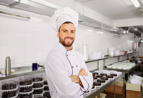Man confectioner with a cake in his hands in the pastry. - Foto, Imagem