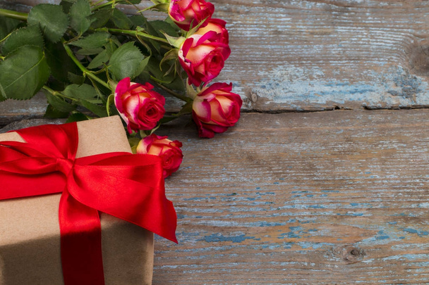 Woo έννοια ημέρα του Αγίου Βαλεντίνου με κόκκινο τριαντάφυλλο λουλούδια και σε συσκευασία δώρου - Φωτογραφία, εικόνα