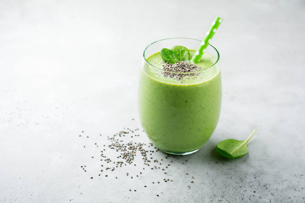 Vegetarian healthy green smoothie from avocado, spinach leaves, apple and chia seeds on gray concrete background. Selective focus. Space for text. - Fotoğraf, Görsel