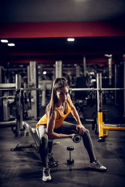 schöne sportliche junge Frau beim Training mit der Hantel im Fitnessstudio - Foto, Bild