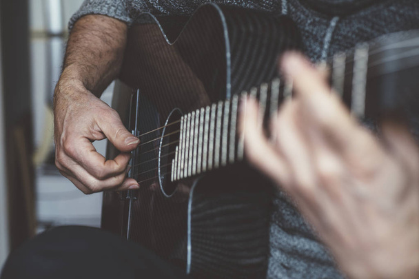 Пожилой человек играет на углеродной гитаре
 - Фото, изображение