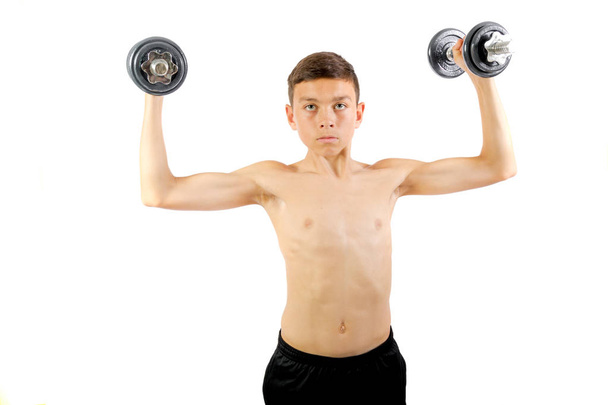 Teenage boy exercising with dumbbells - Foto, afbeelding