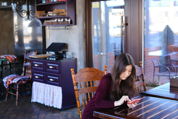 Δάσκαλος ελέγχοντας δοκιμές στο café χρησιμοποιώντας smartphone - Φωτογραφία, εικόνα