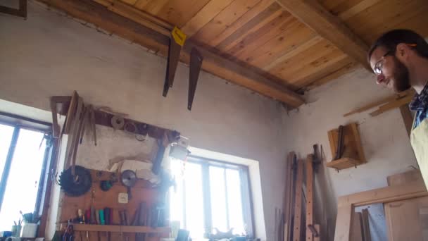 Stylové zpracování dřeva Průvodce používá nástroj držený v ruce. Zdi stojí s truhlářem s jiný nástroj - Záběry, video