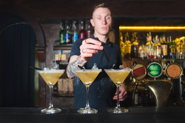 Barman stworzył piękny koktajle alkoholowe w nocnym klubie. Barman sprawia, że piękny cocktail. - Zdjęcie, obraz