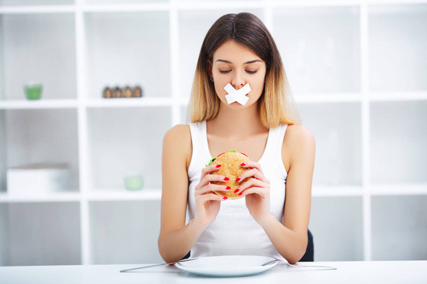 Diet. Young beautiful woman eating burger, It's junk and unhealt - Фото, зображення