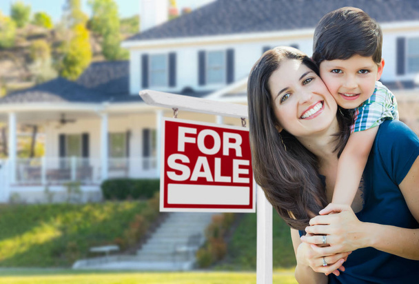 junge Mutter und Sohn vor zu verkaufendem Immobilienschild und Haus. - Foto, Bild