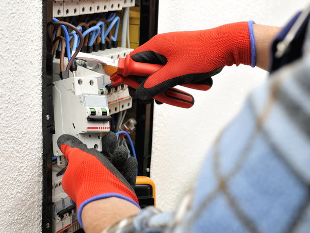 Young electrician technician at work on a electrical panel with  - Photo, Image