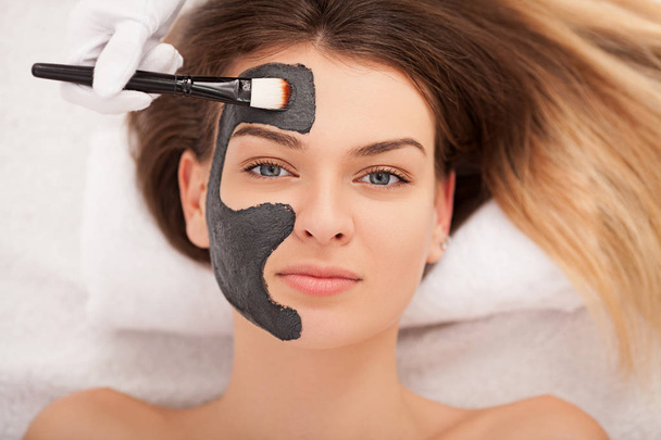 Spa concept. Young woman with nutrient facial mask in beauty sal - Photo, Image