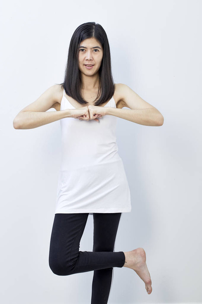 Elegante mujer joven asiática con estilo en vestido de ejercicio blanco, haciendo yoga, concepto para la salud
 - Foto, imagen