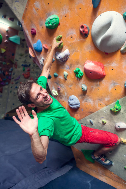 A rock climber is in a bouldering hall. - Photo, Image