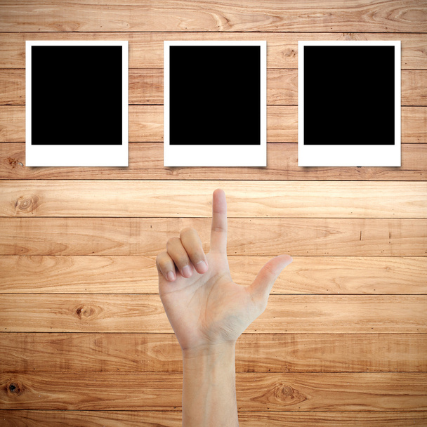 Polaroid ramki na tle drewna z wierceń palec ręki - Zdjęcie, obraz