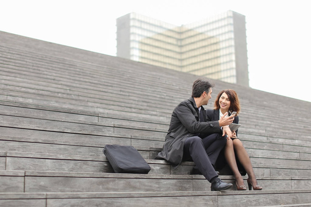 male and female office workers spend break sitting on stair - Zdjęcie, obraz