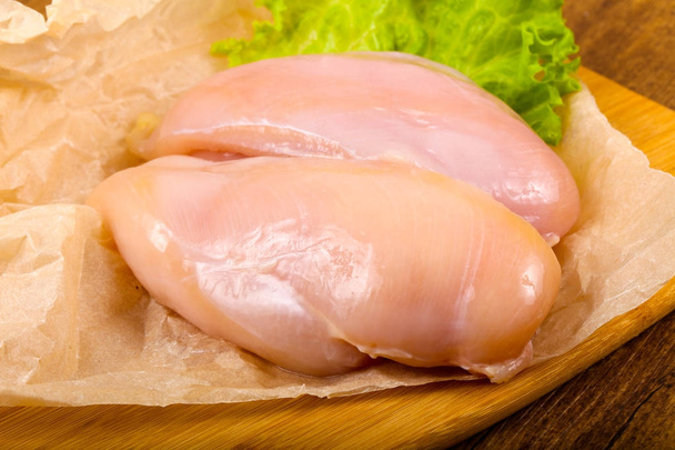 Ωμό κοτόπουλο στήθος με σαλάτα αφήνει στο ξύλο παρασκήνιο - Φωτογραφία, εικόνα