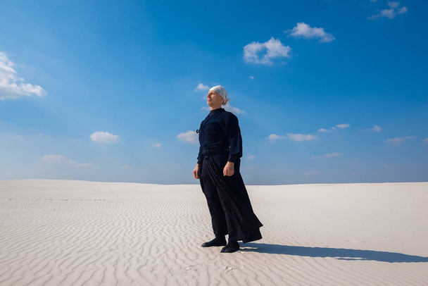 Focused man standing in the desert and meditates - Valokuva, kuva
