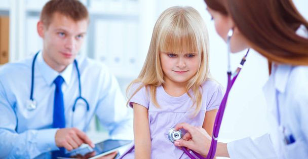 Ärztin untersucht Kind mit Stethoskop bei Operation - Foto, Bild