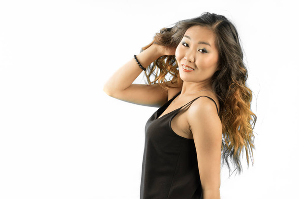 красивая азиатская женщина исправление ее длинные кудрявые волосы изолированы на белом фоне
 - Фото, изображение