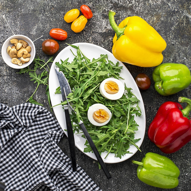 Paskalya bahar salatası ile taze sebze: domates, roka, yumurta, fındık ve kruton gri grunge arka plan üzerinde. Üstten Görünüm.. - Fotoğraf, Görsel