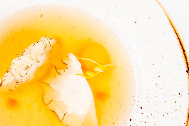 Dumplings in broth with an egg yolk on a white background - Foto, Imagen
