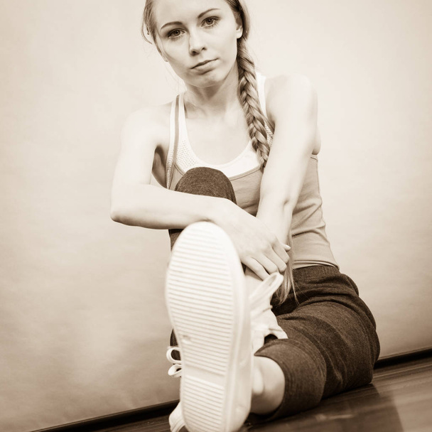 Woman in sportswear sitting on ground - Fotografie, Obrázek