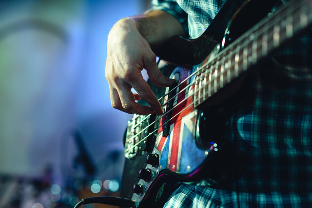 closeup rockstar on stage playing on electro guitar. Male guitarist - Fotografie, Obrázek