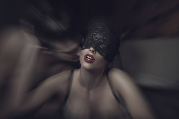 Seksikäs nainen silmät sidottuina ja punaiset huulet nuori rakastaja sängyssä
 - Valokuva, kuva