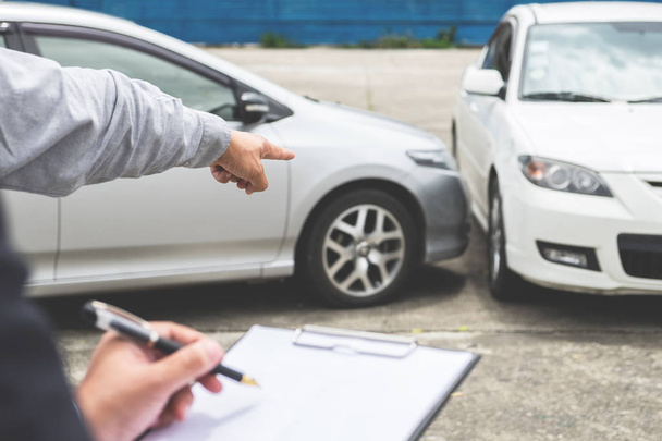 Insurance Agent examine Damaged Car and filing Report Claim Form - Valokuva, kuva