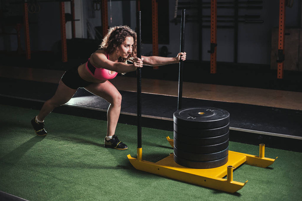 sled push woman pushing weights workout exercise - Foto, imagen