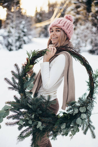 Noel çelenk kış ormandaki sarışın genç bir bayanla - Fotoğraf, Görsel