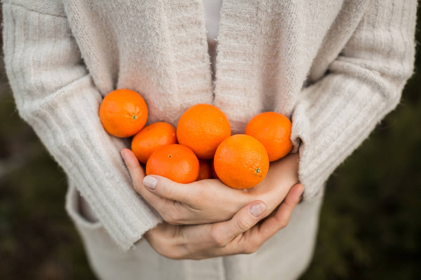  girl is holding tangerines - 写真・画像