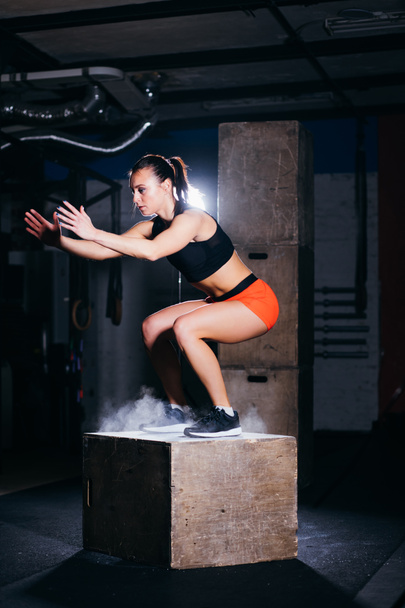 woman jumping box. Fitness woman doing box jump workout at cross fit gym. - Zdjęcie, obraz
